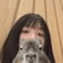 a close up of a person holding a cat in front of their face .