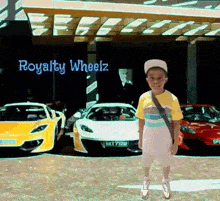 a boy is standing in front of a building that says royalty wheelz on it