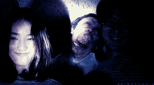a woman and two men are smiling in a dark room with the word spiraphobia on the bottom left