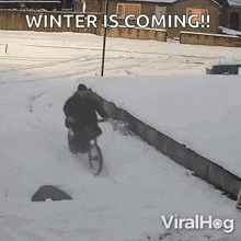 a man riding a bike in the snow with the words winter is coming on the bottom
