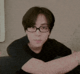 a man wearing glasses and a black shirt