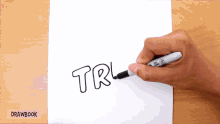 a person is drawing the word trl with a sharpie marker