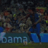 a soccer game is being played in front of a green sign that says ' emma ' on it