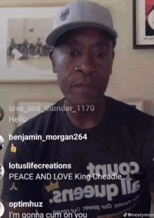 a man wearing a hat and a shirt that says peace and love king cheadle