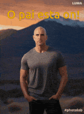a man with his hands in his pockets stands in front of a mountain with the words pai esta on written above him