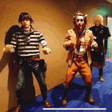 a group of people are standing next to each other in a hallway and one of them is wearing a striped shirt .