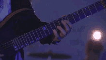 a close up of a person playing a guitar with a k on the neck .