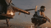 a man kneeling down with a gun in front of a plane