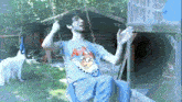 a man wearing a blue shirt with a minion on it is swinging on a swing set