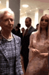 two women are standing next to each other in a room