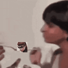 a woman with a mask on her face is eating from a glass