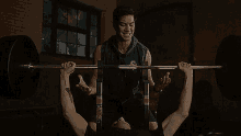 a man is teaching another man how to lift a barbell on a bench .