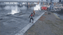 a man in a spiderman costume is holding a rope over another man laying on the ground