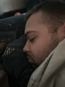 a man with a beard sleeping on a couch