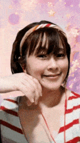 a woman wearing headphones and a headband looks at the camera and smiles