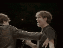 a couple of men are giving each other a high five .