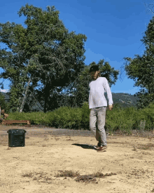 a man in a white shirt is walking in a field