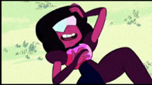 garnet from steven universe is laying on the ground holding a heart shaped object .