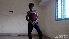 a man in a red tank top is dancing in front of a window in a room made with vivavideo