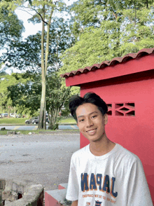 a young man wearing a white t-shirt that says ' masal ' on it