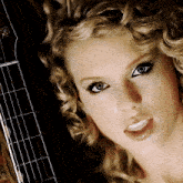 a close up of a woman 's face and a guitar