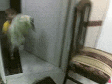 a blurred image of a person standing next to a chair in a hallway