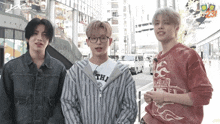 three young men are standing next to each other with one wearing a shirt that says ' tokyo ' on it