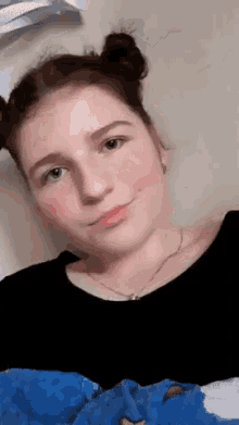 a girl with two buns in her hair and a black shirt