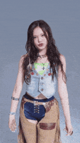 a woman in a denim vest and shorts is making a face