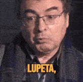 a man wearing glasses and a scarf has the word lupeta above his head