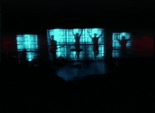 a silhouette of people standing in front of a window