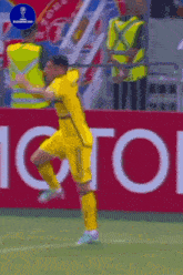 a soccer player is jumping in the air in front of an toyota sign