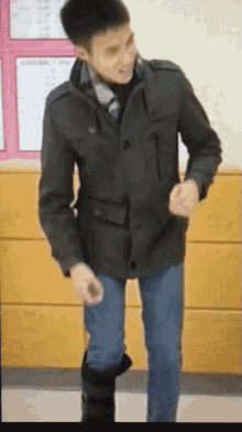 a man in a jacket and tie is dancing