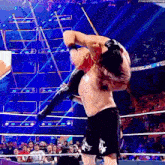 a man is wrestling another man in a wrestling ring while holding a spear .