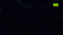 a white light is shining on a dark background with green dots
