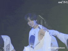 a man in a white adidas shirt is standing next to another man in a white shirt .