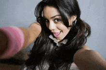 a woman is taking a selfie with her tongue out while wearing pigtails .