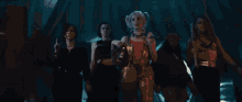 a group of people are standing next to each other in a dark room holding guns .