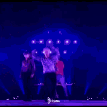a blurry picture of two men dancing on a stage with a purple background .