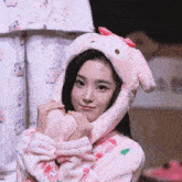 a girl wearing a pink bunny hat with ears and a bow