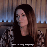 a woman is sitting at a table and says " look i 'm sorry if i upset ya "