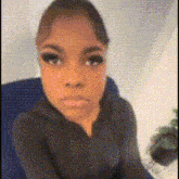 a woman in a black shirt is sitting in a chair making a funny face .