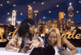 two women are sitting in front of a city skyline with the word bride in the background