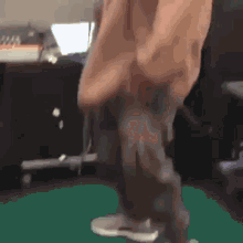 a blurry picture of a person 's legs and feet on a green surface