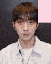 a young man wearing earbuds and a striped shirt