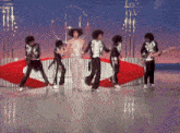 a group of people are dancing on a stage in front of a sign that says ' a ' on it