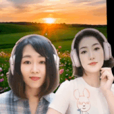 two women wearing headphones in front of a field