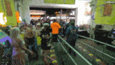 a crowd of people are gathered in a room with a sign that says cooemuv1 on it