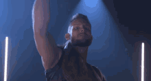 a man with long hair and a beard is standing in front of a blue light