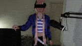a man wearing a blue jacket and a pink wig is standing next to a microphone